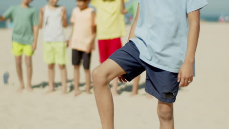 Vertical-motion-of-smiling-boy-lifting-soccer-ball-off-ground